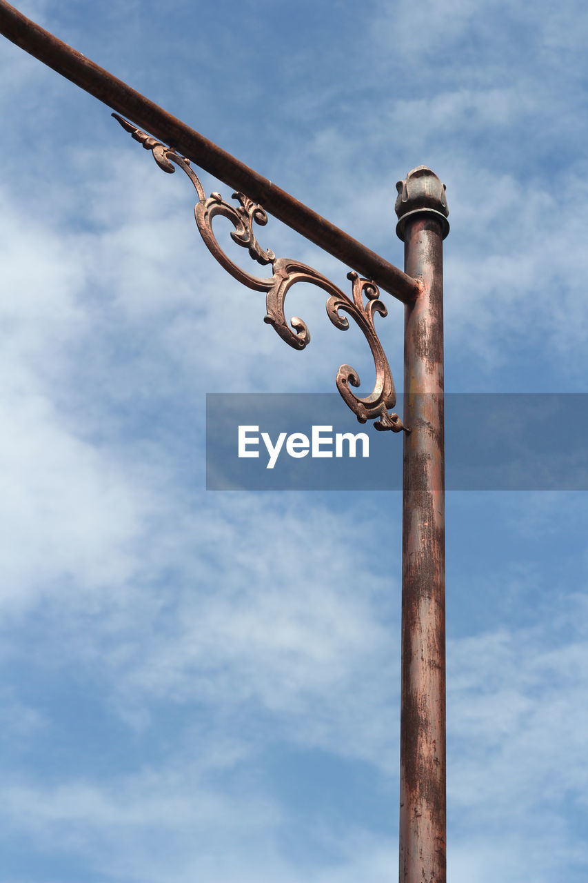 LOW ANGLE VIEW OF METALLIC POLE AGAINST SKY