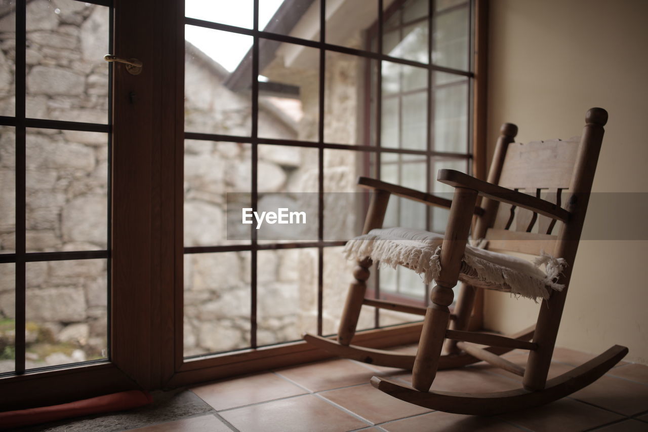 Empty rocking chair next to the window at home