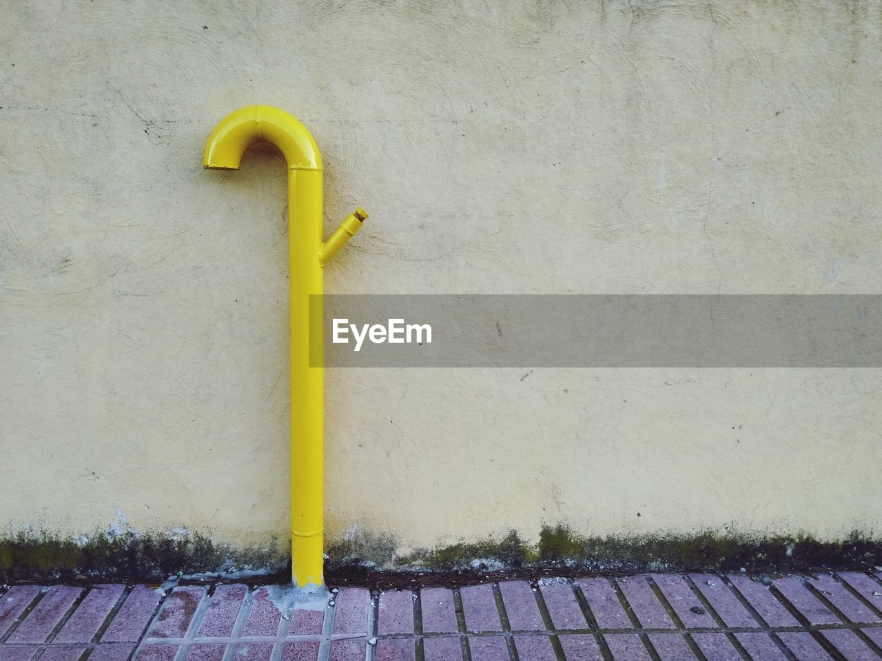 CLOSE-UP OF YELLOW WALL WITH UMBRELLA