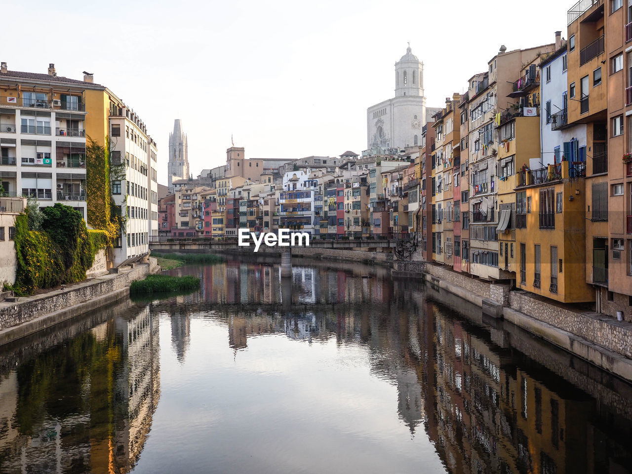 Reflection of buildings in canal against sky