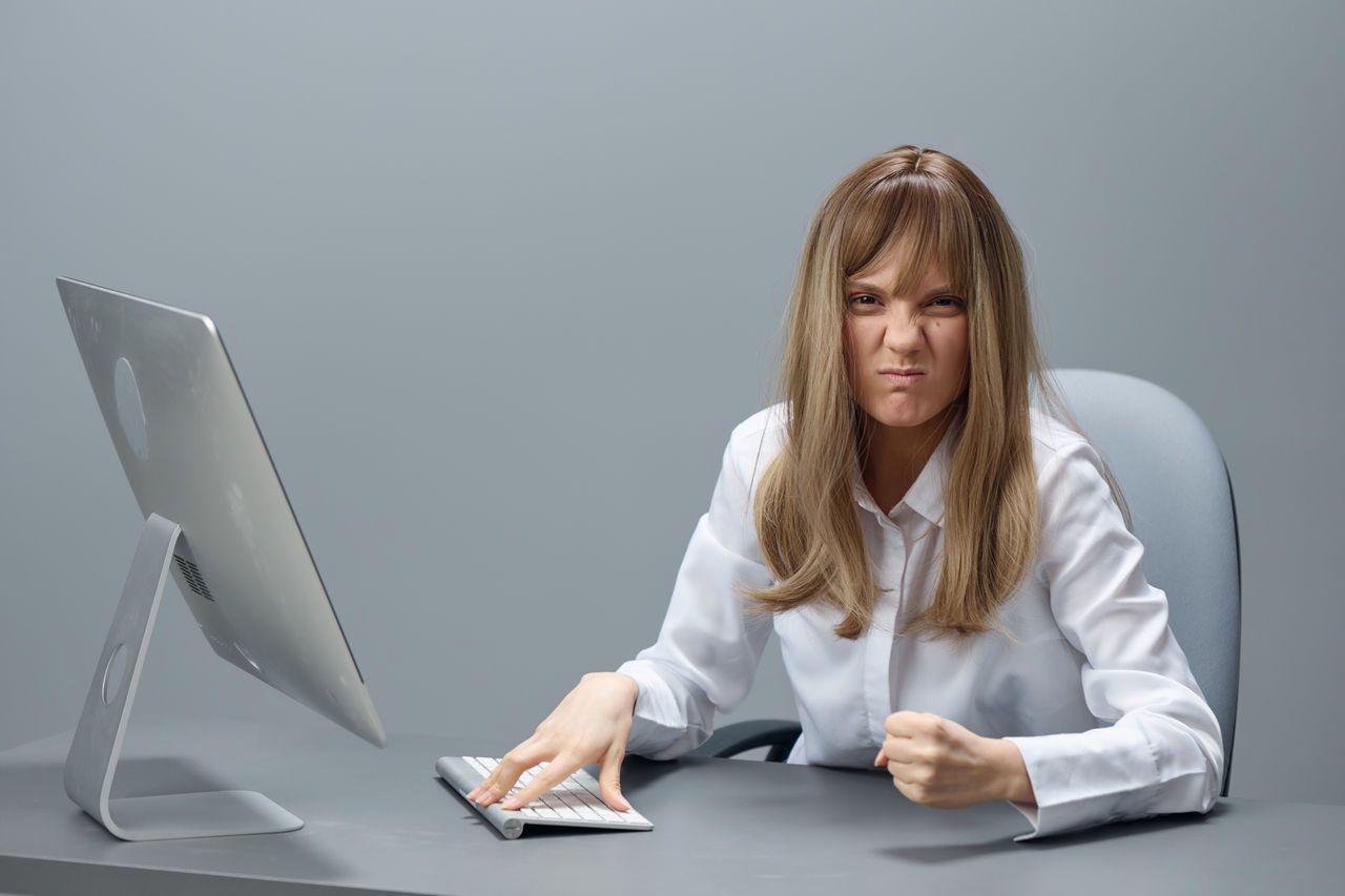 portrait of young woman using mobile phone while sitting on table