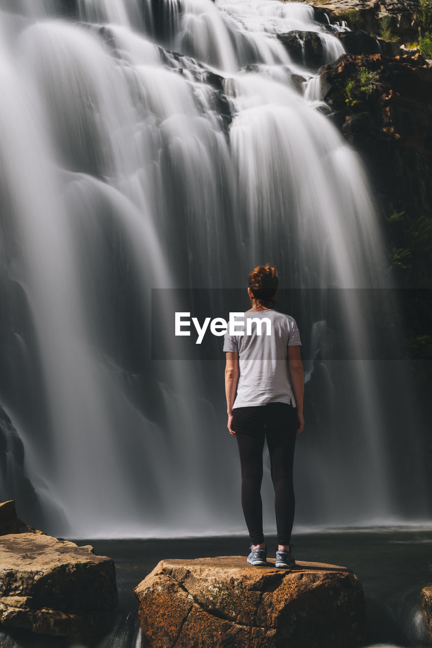 Young woman stares at mackenzie waterfalls at the grampians national park, victoria, australia