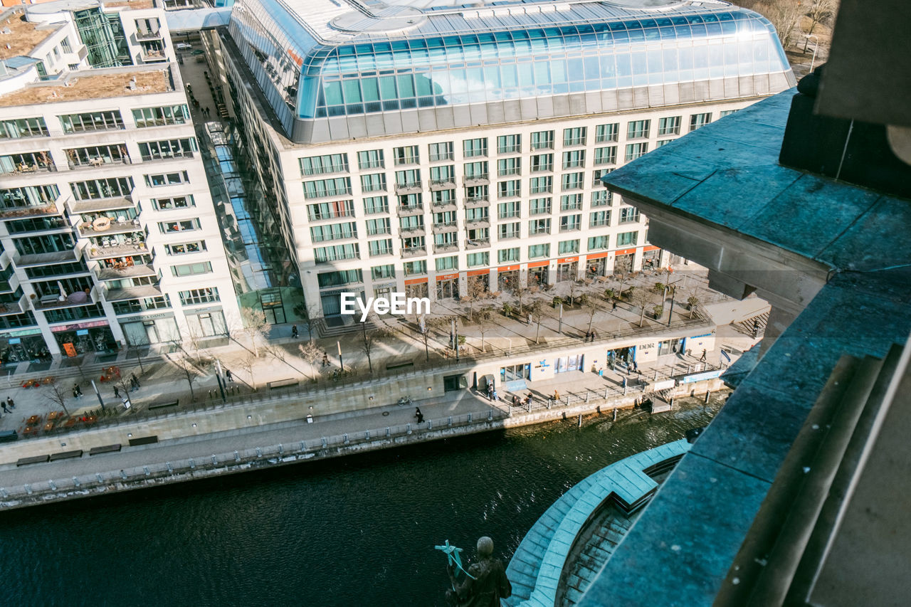 HIGH ANGLE VIEW OF BUILDINGS BY RIVER SEEN THROUGH WINDOW