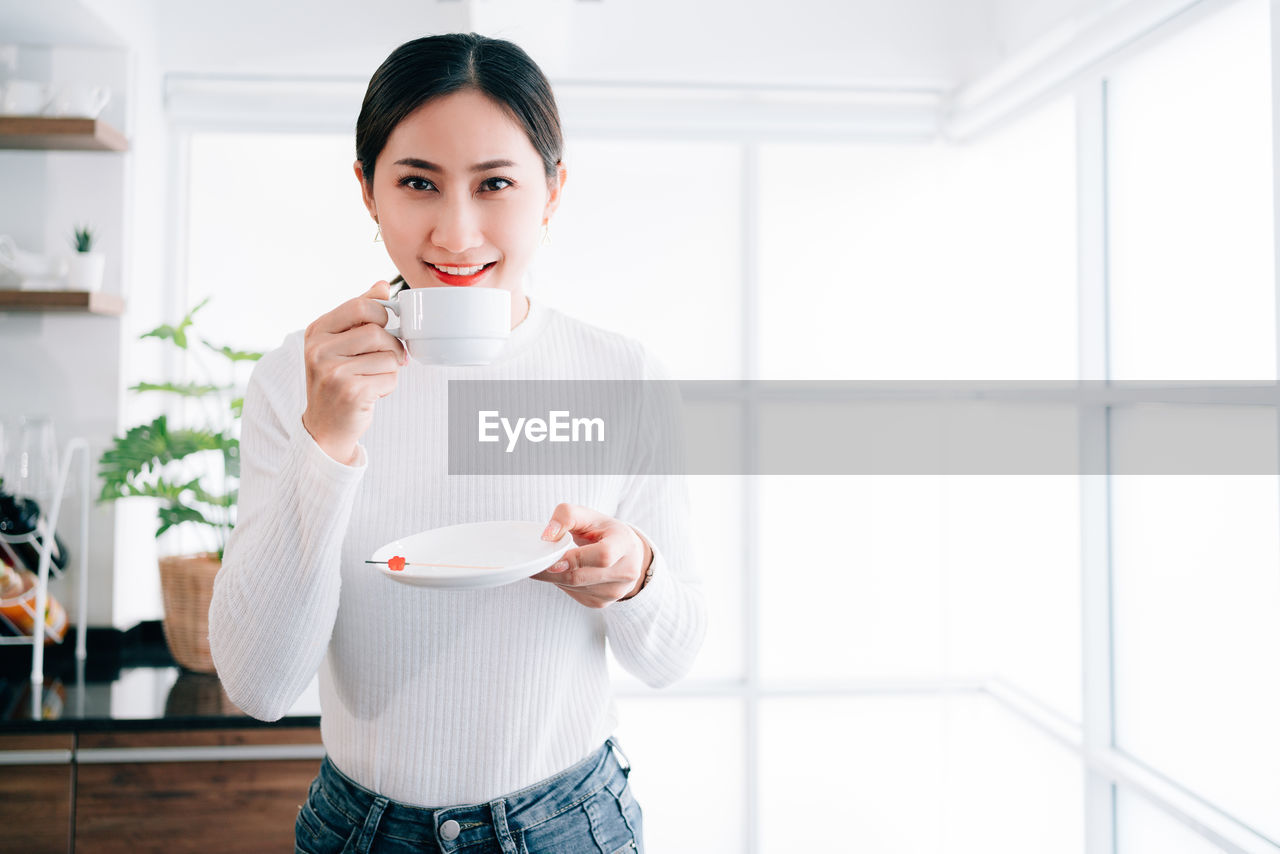 Portrait of smiling woman holding coffee cup