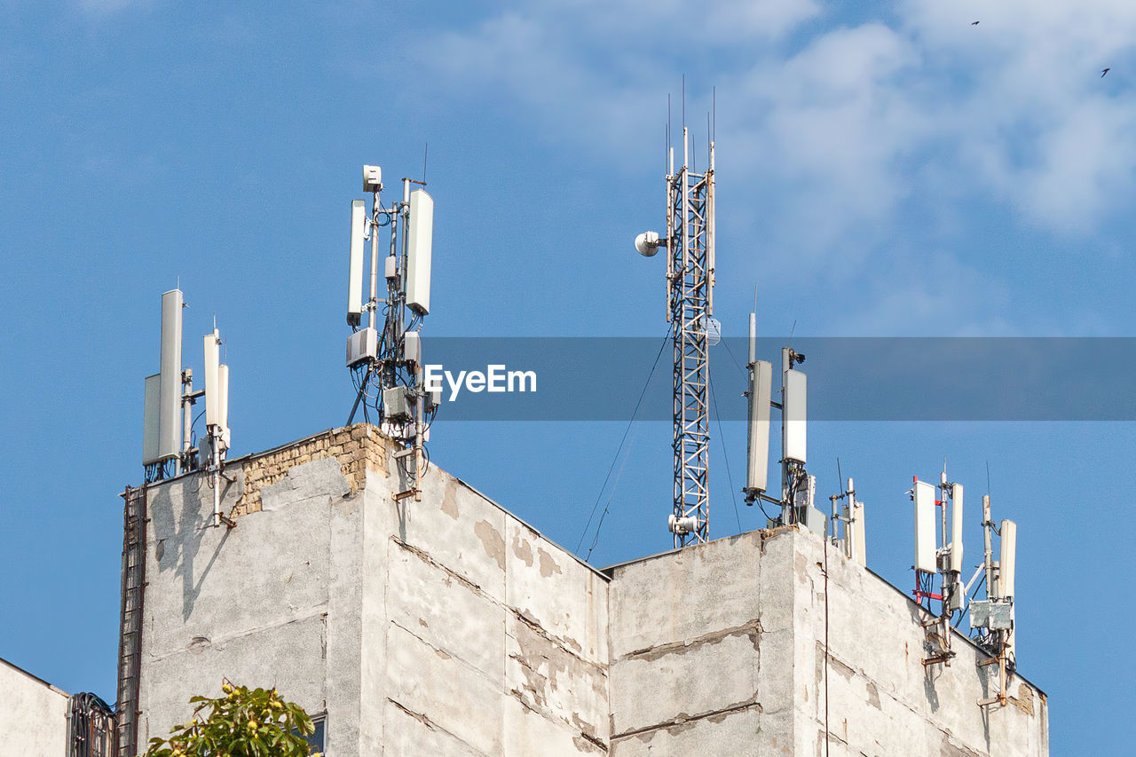 Telecommunication tower with 5g cellular network antenna on city background