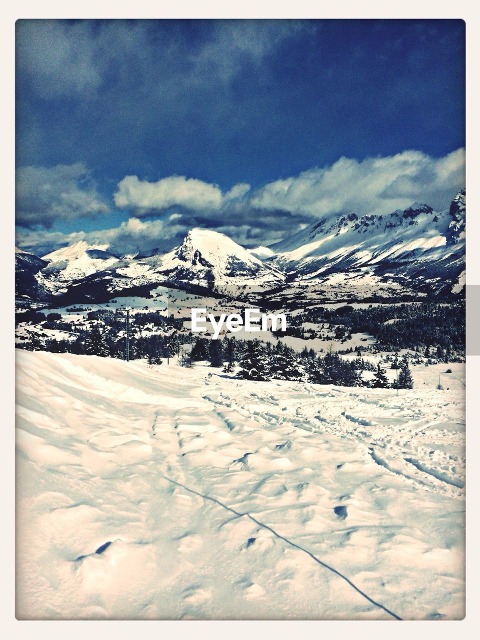 Snowcapped landscape and mountains against sky