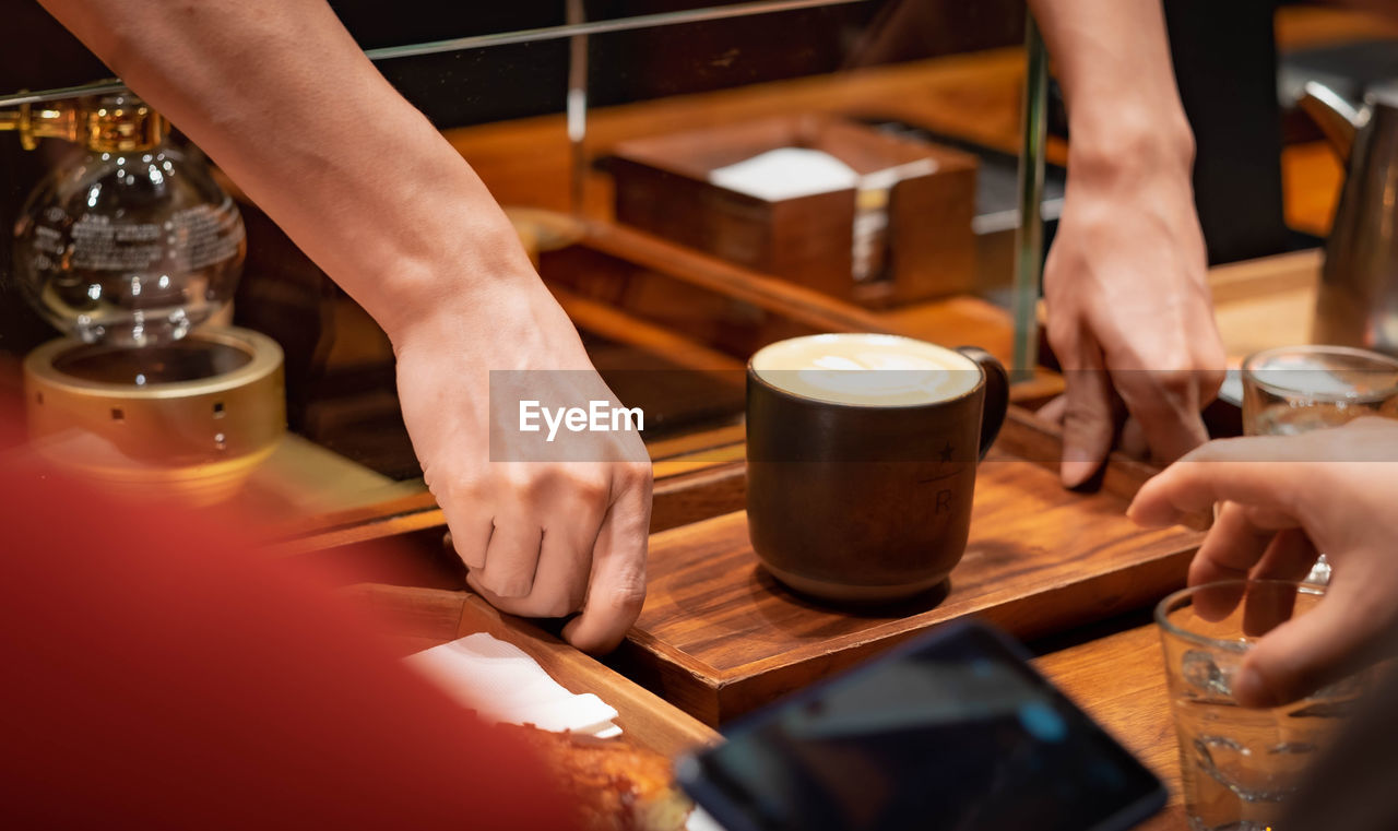 Midsection of woman holding drink at restaurant