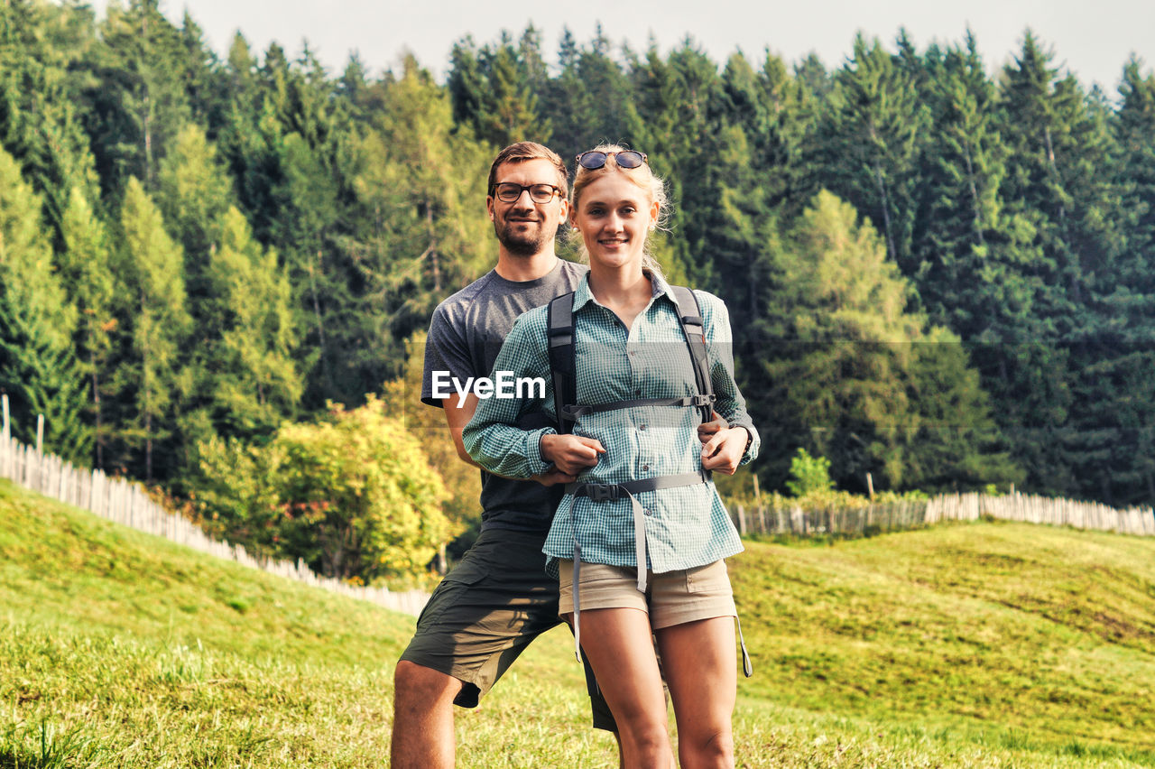 Portrait of smiling young woman standing on land