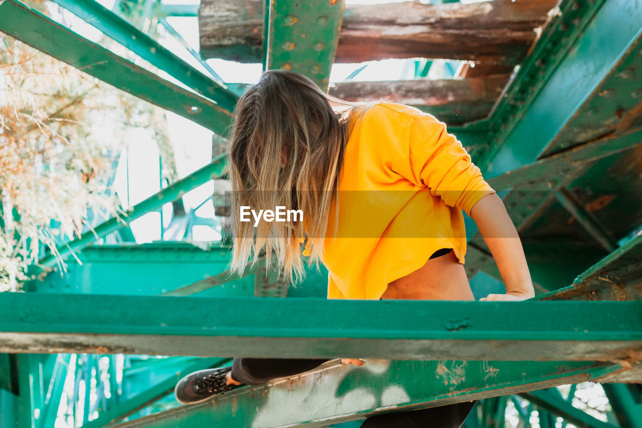 Young woman sitting on railway bridge