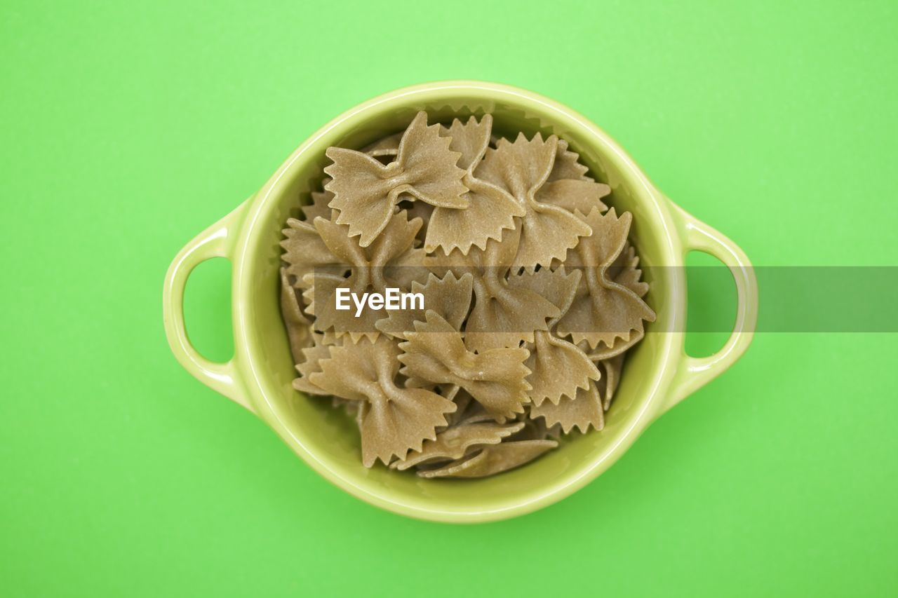 High angle view of pasta in bowl against green background