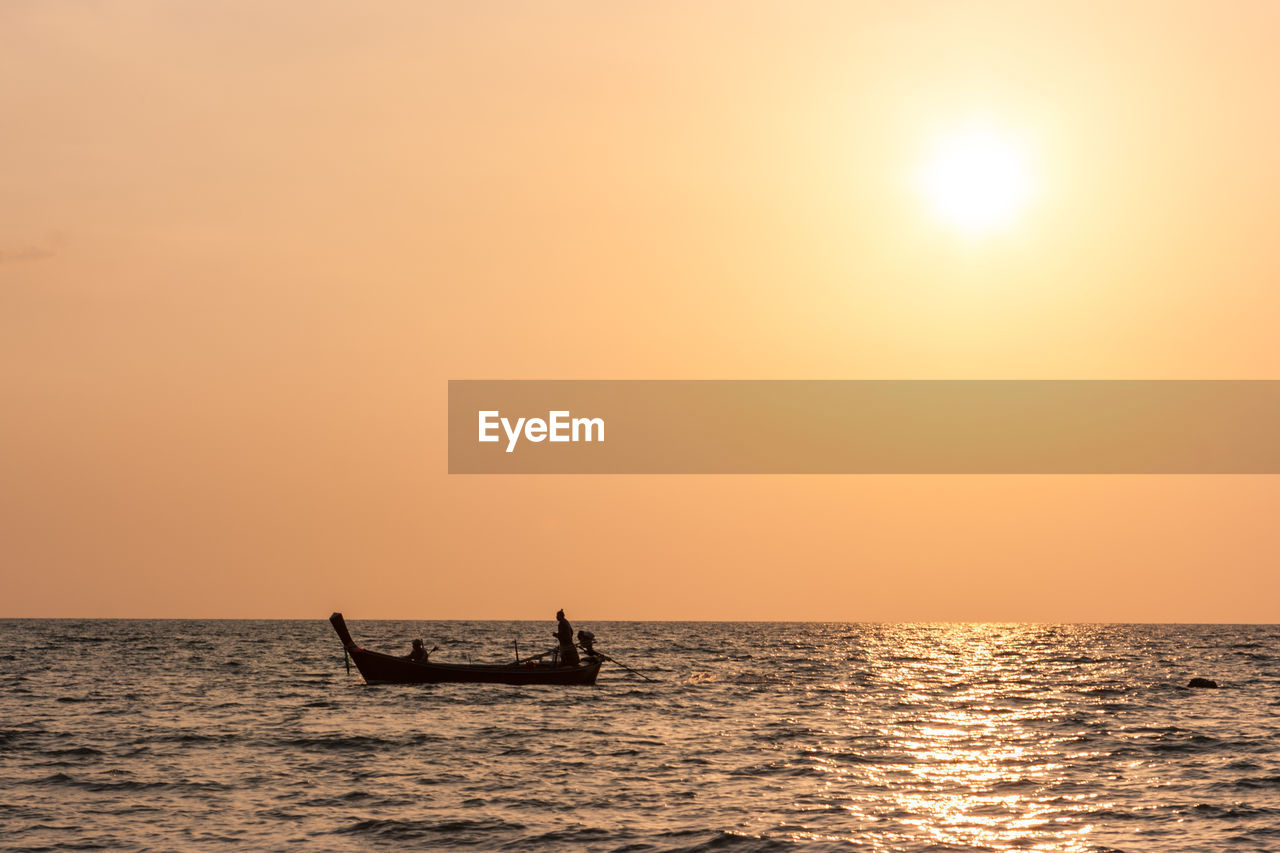 SILHOUETTE SHIP IN SEA AGAINST SKY DURING SUNSET