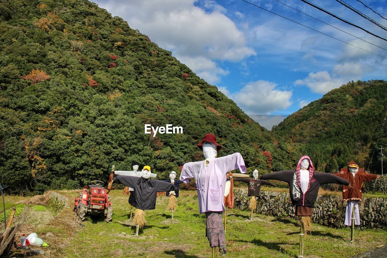 Scarecrow on field against sky