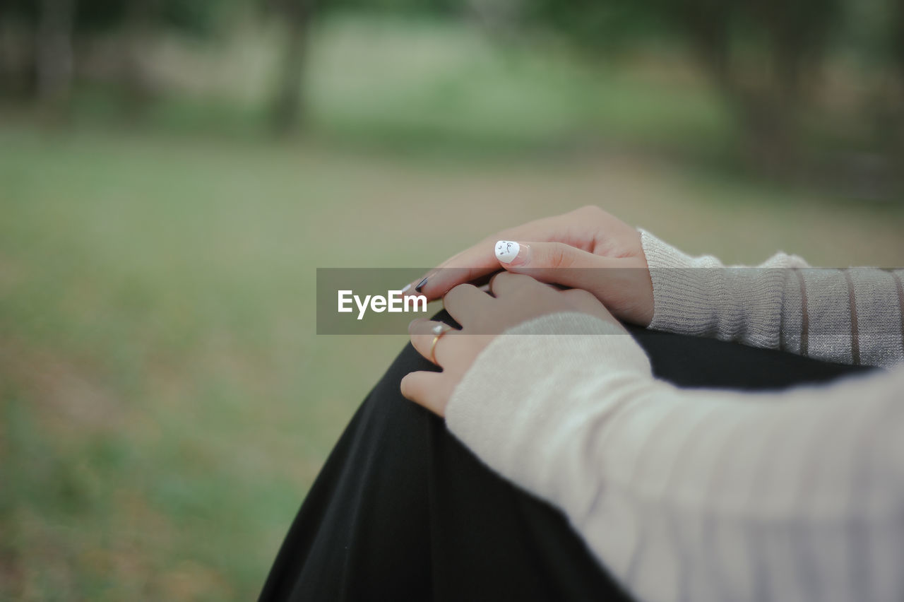 CLOSE-UP OF WOMAN HAND ON FINGER AGAINST BLURRED MOTION