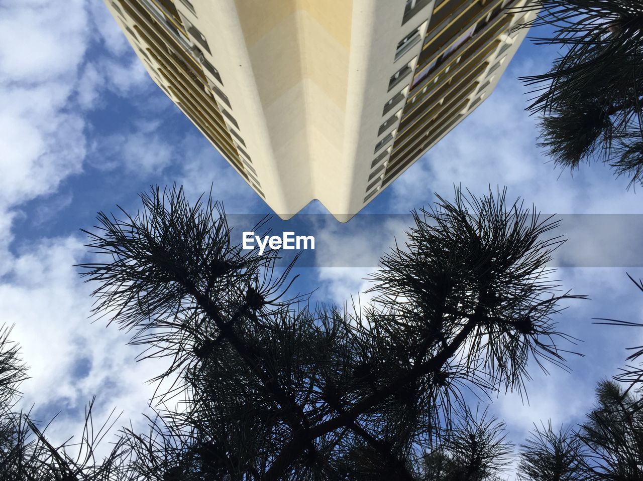 LOW ANGLE VIEW OF MODERN BUILDING AGAINST CLOUDY SKY