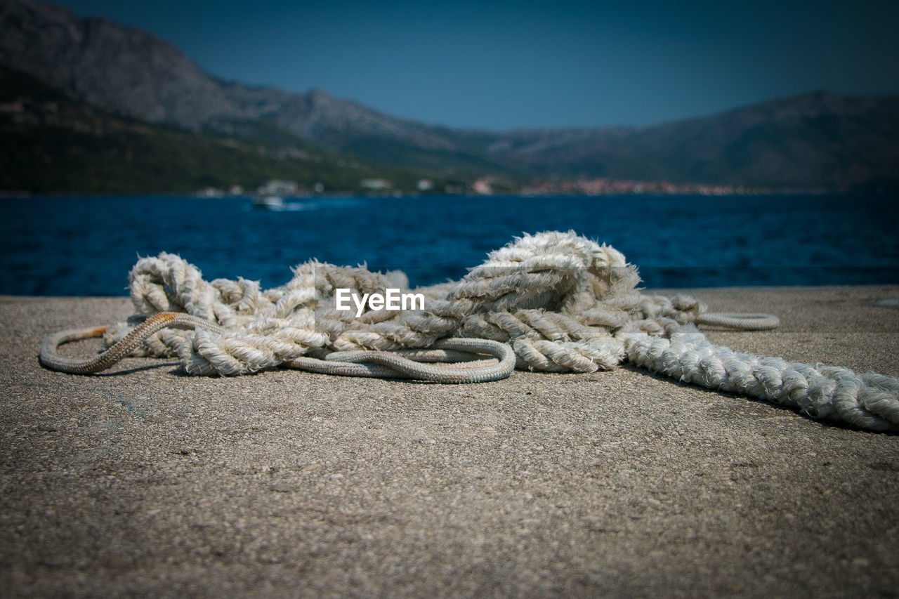 Close-up of rope on pier at harbor