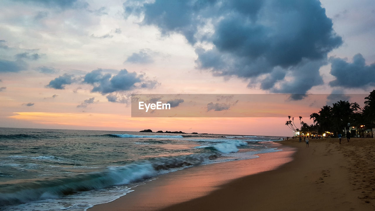 Scenic view of beach against sky during sunset