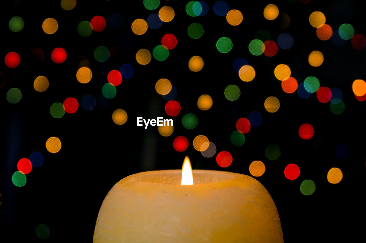 High angle close-up of glowing candle during christmas