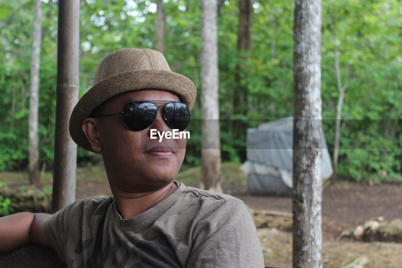 Portrait of man wearing sunglasses in forest