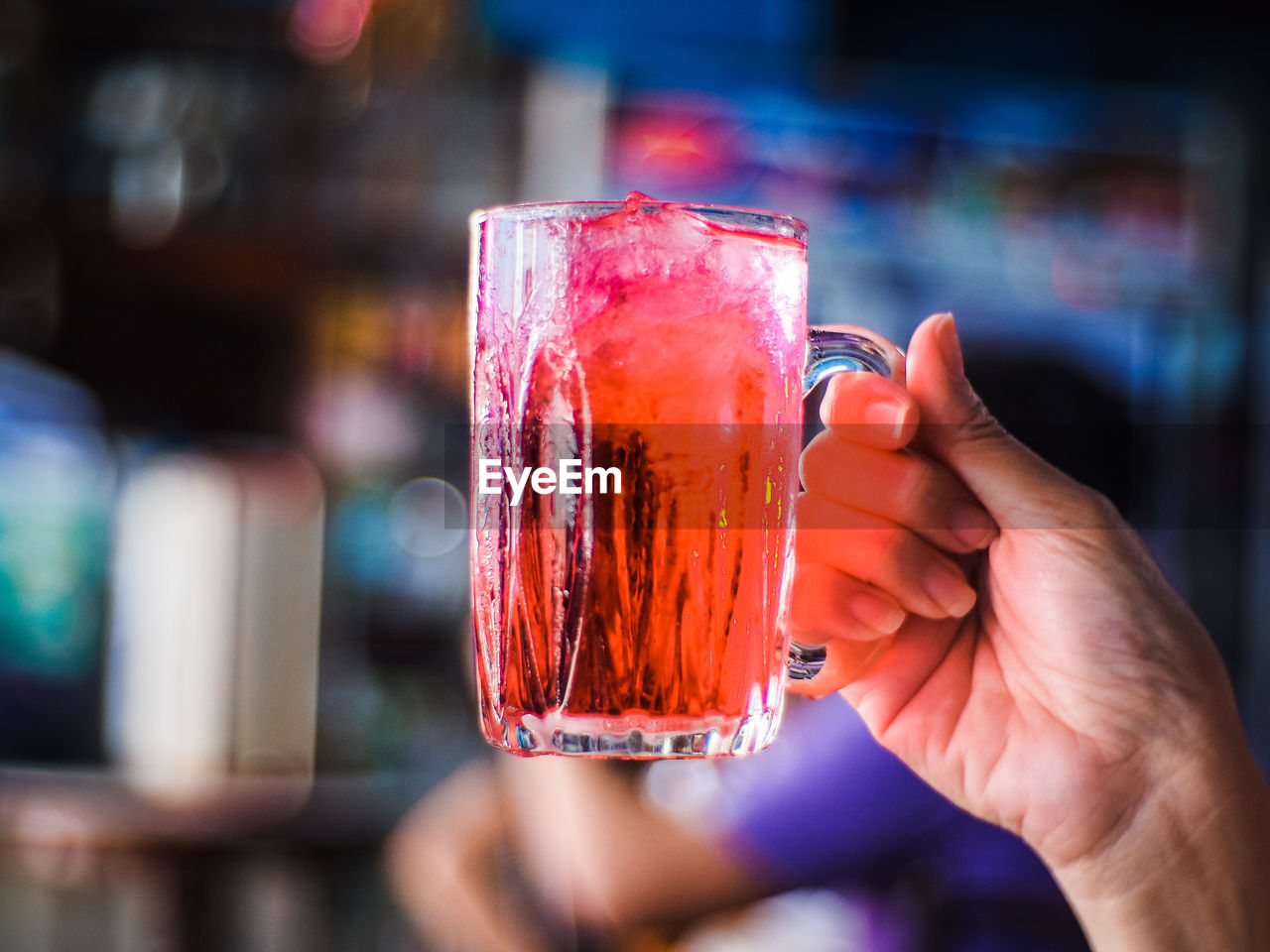 CLOSE-UP OF HAND HOLDING DRINK