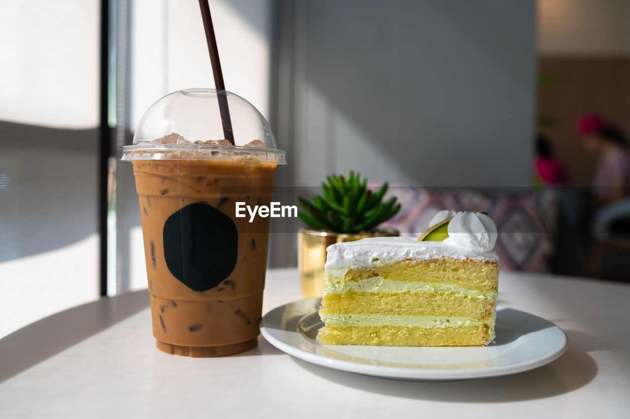 Iced coffee with melon cake on white table in restaurant