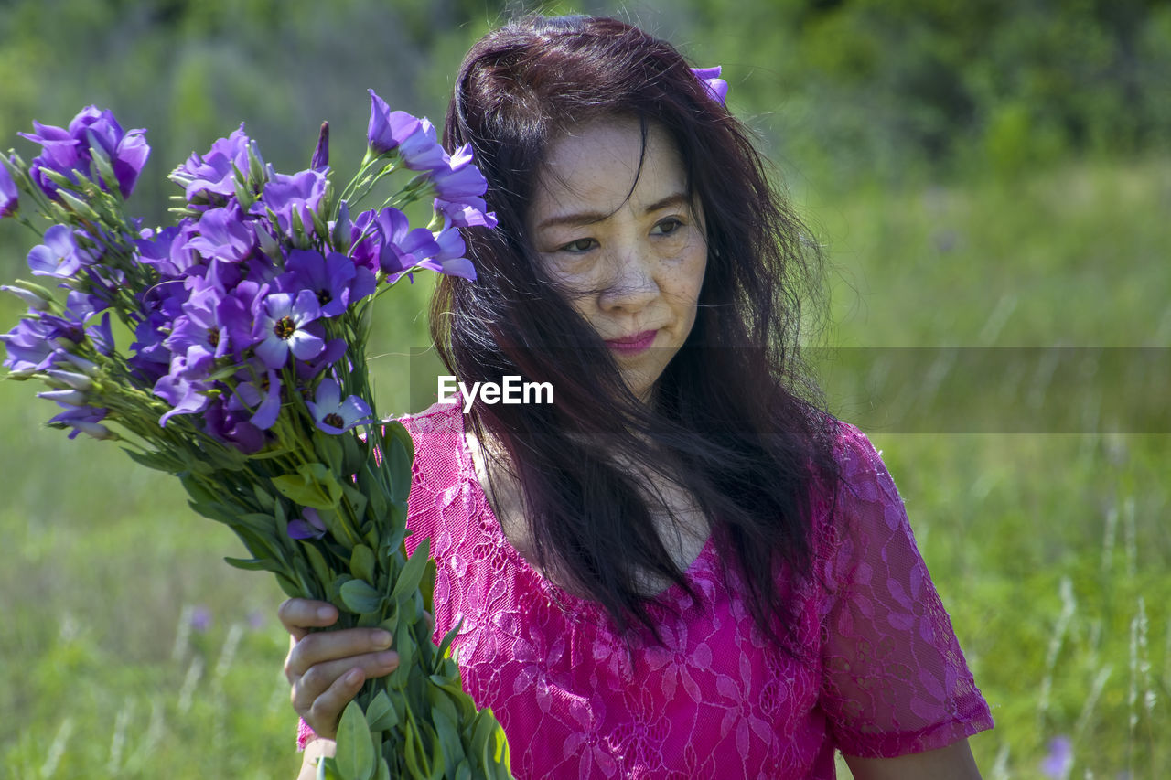 PORTRAIT OF WOMAN WITH PURPLE FLOWERS