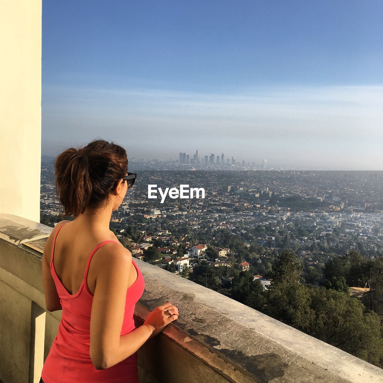 Woman looking at city against sky