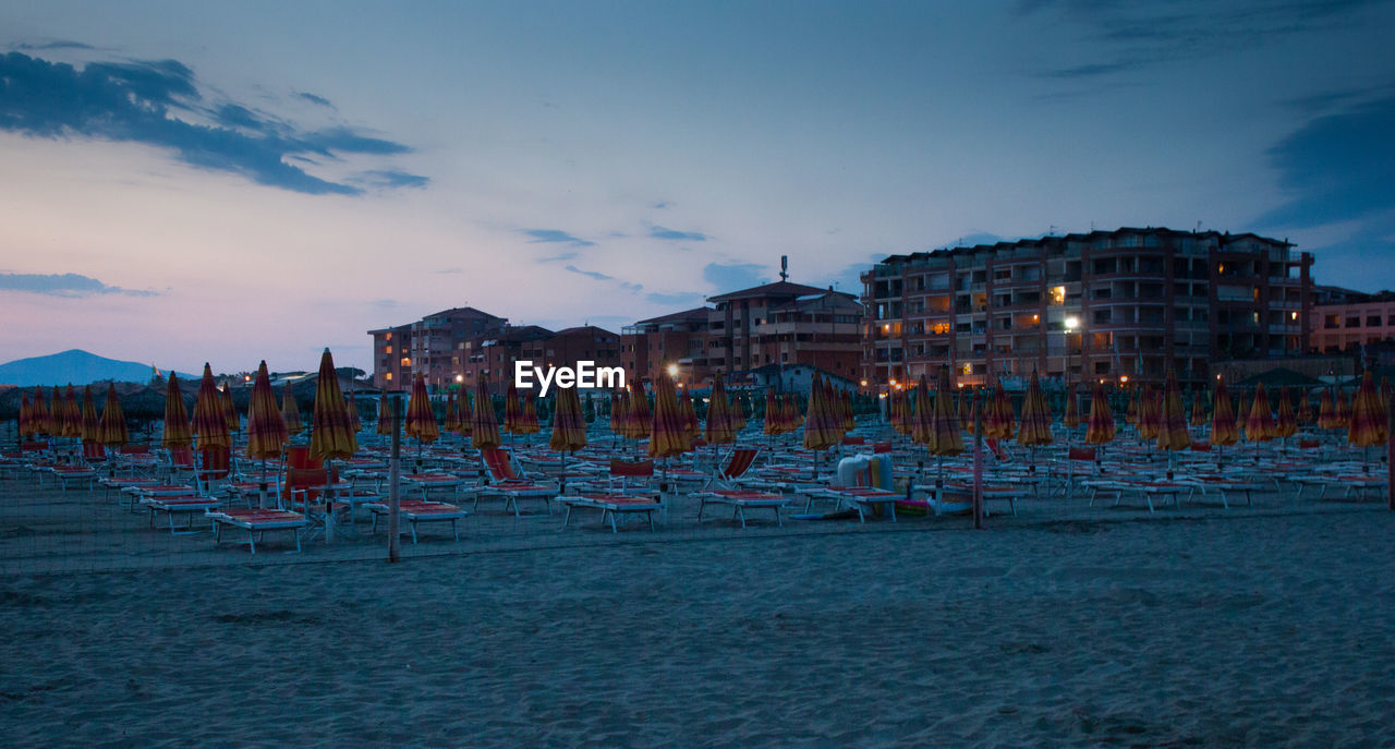 PANORAMIC VIEW OF BEACH AGAINST ILLUMINATED BUILDINGS IN CITY