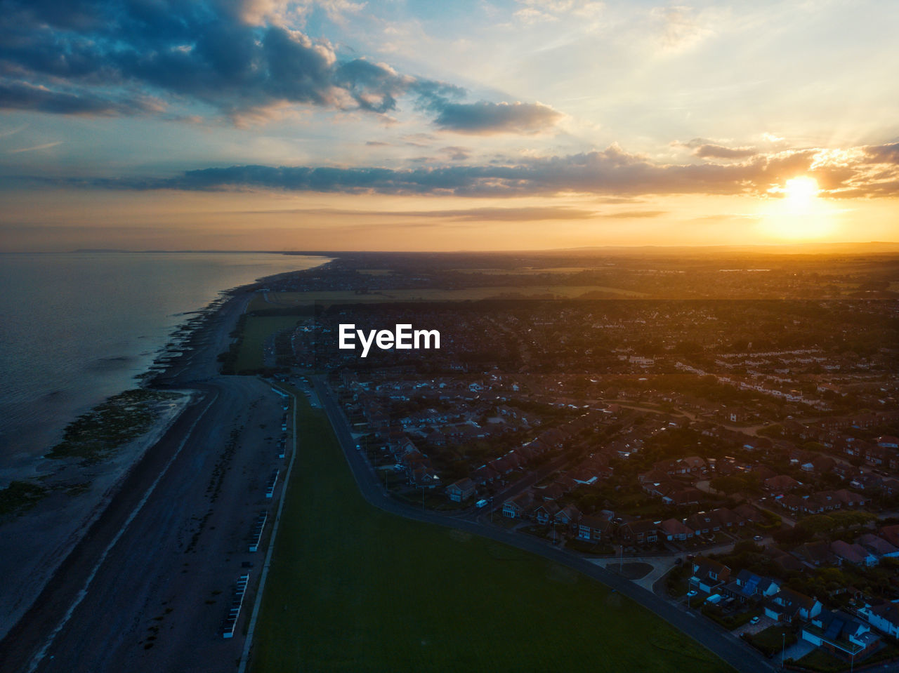 HIGH ANGLE VIEW OF RIVER BY CITYSCAPE AGAINST SKY DURING SUNSET