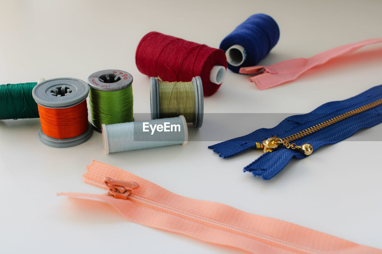 thread, spool, textile, sewing, sewing item, craft, indoors, studio shot, wool, material, variation, ball of wool, art, multi colored, group of objects, creativity, still life, textile industry, white background, cotton, scissors, blue