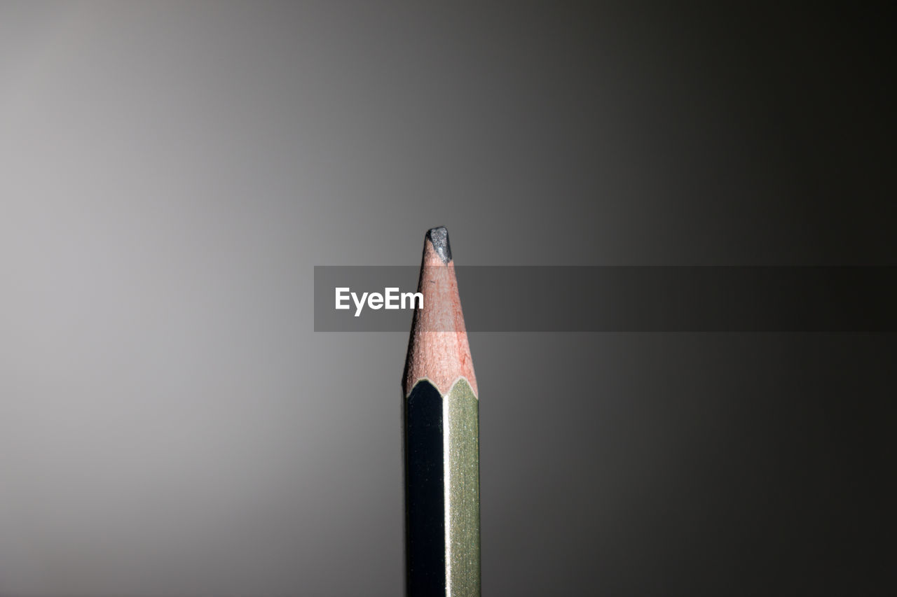 Close-up of pencil against gray background