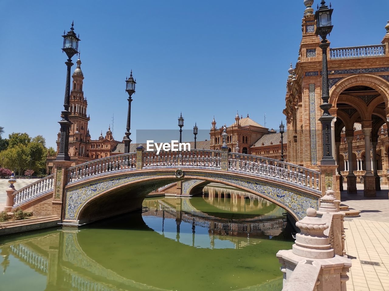 Arch bridge over river against sky in city