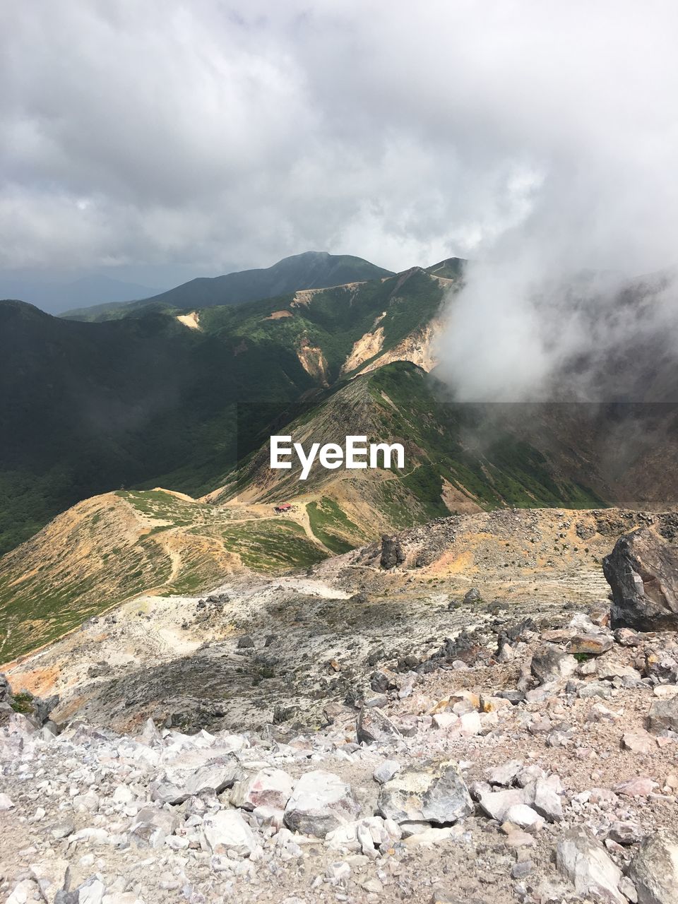 SCENIC VIEW OF MOUNTAINS AGAINST CLOUDY SKY