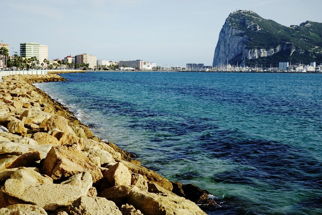 VIEW OF SEA WITH BUILDINGS IN BACKGROUND