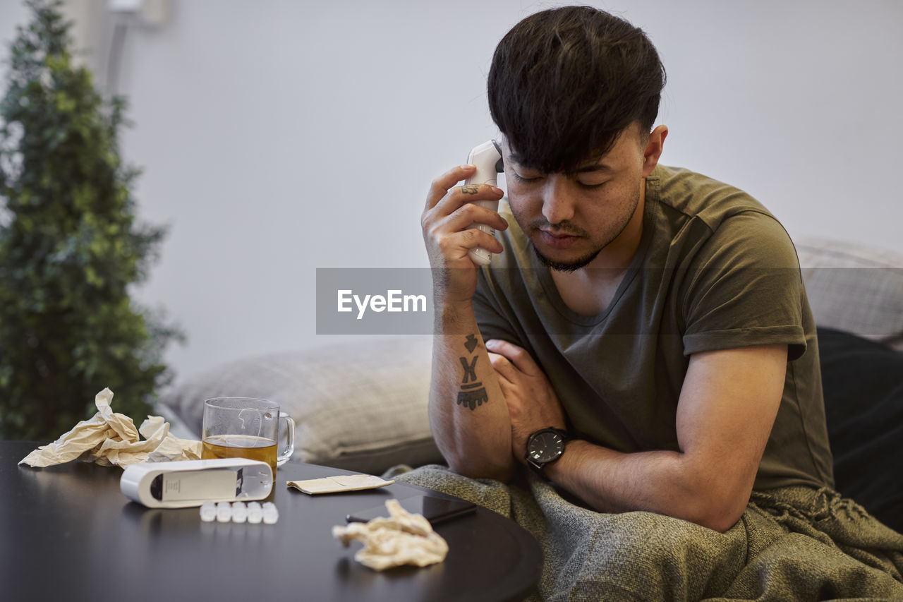 Ill man on sofa using cell phone