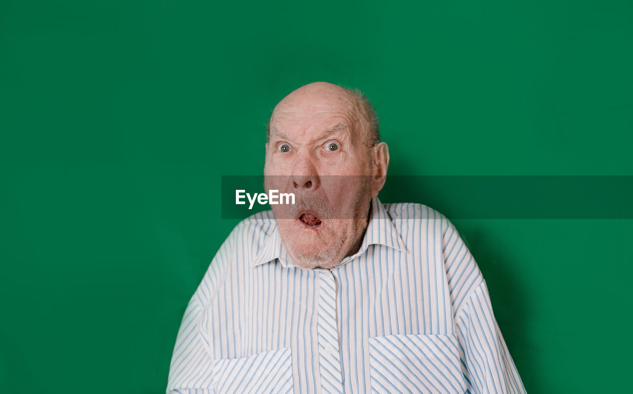 PORTRAIT OF MAN AGAINST BLUE BACKGROUND