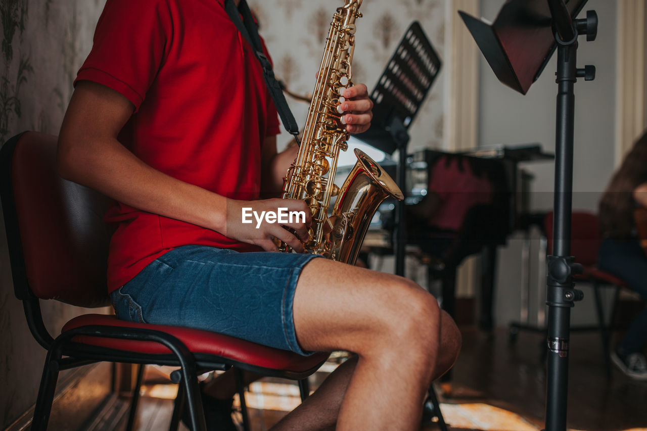 Midsection of man playing saxophone 