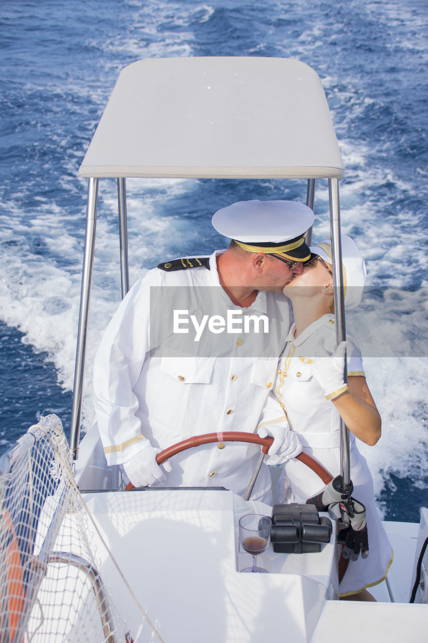 Couple kissing in boat on sea