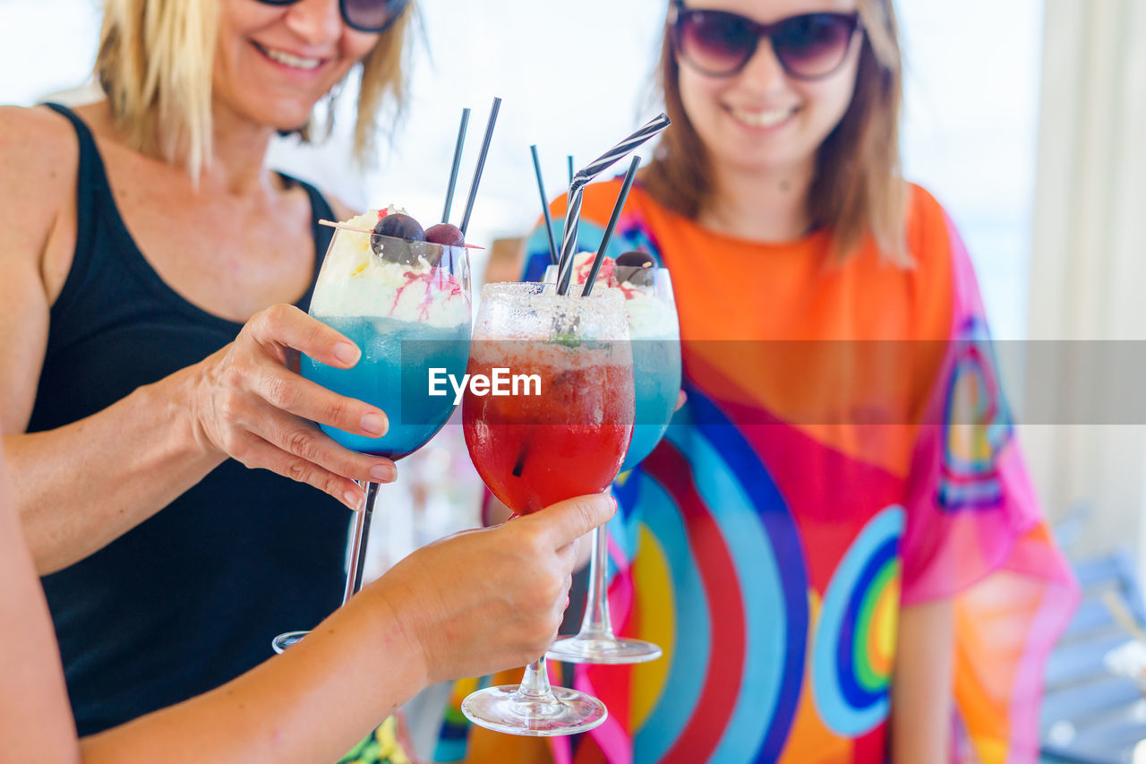 Women holding drink in glasses