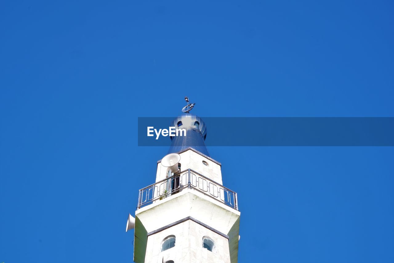 Low angle view of bell tower against blue sky