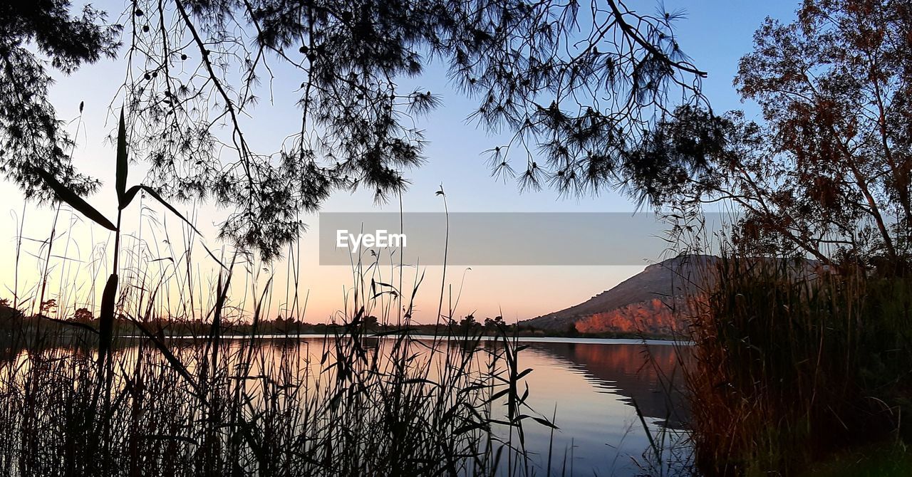 Scenic view of lake against sky during sunset