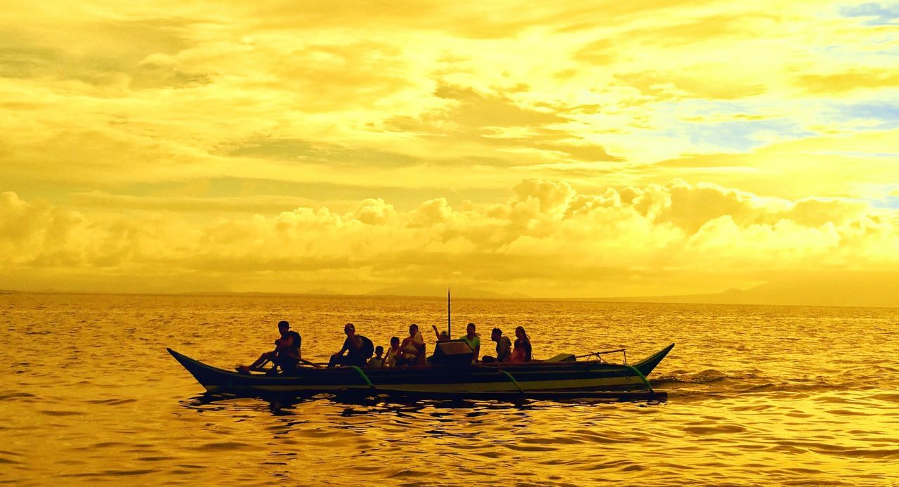 PEOPLE IN SEA AGAINST DRAMATIC SKY