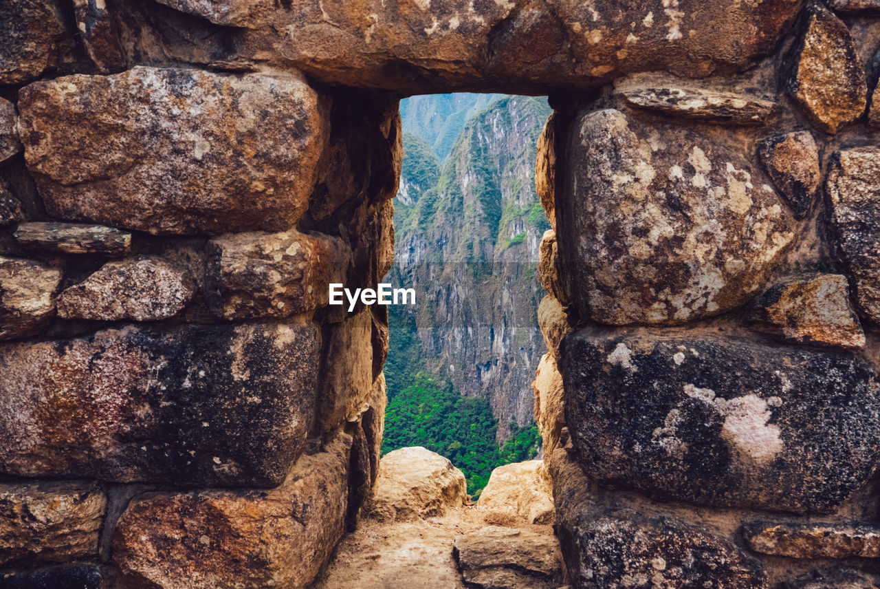Mountain seen through window of old building at machu picchu