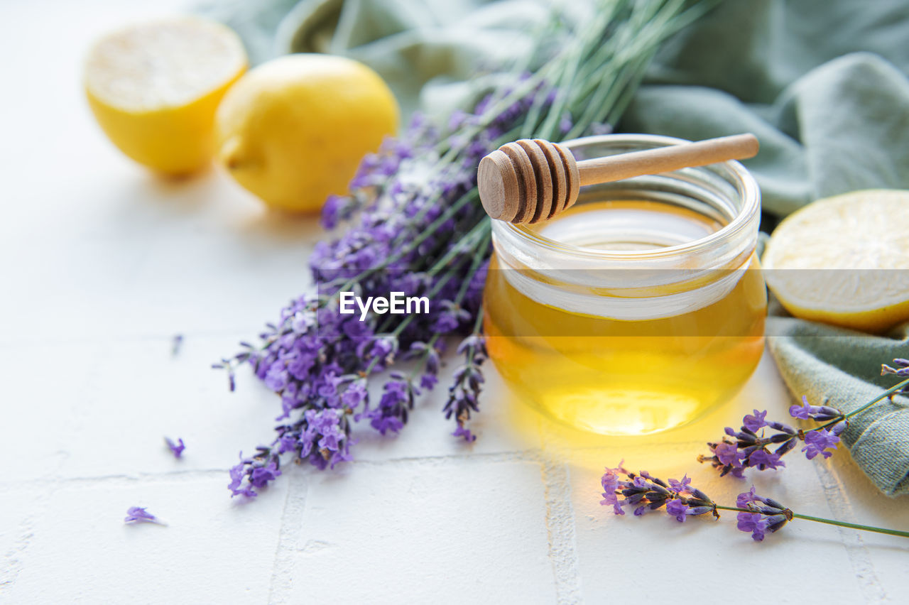 Glass of honey, honeycomb and lavender flowers