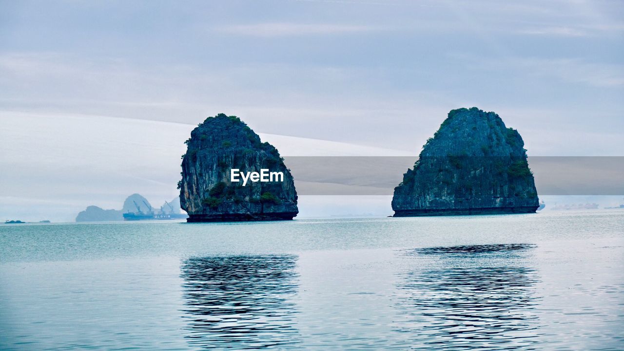 Scenic view of rock formation in sea against sky