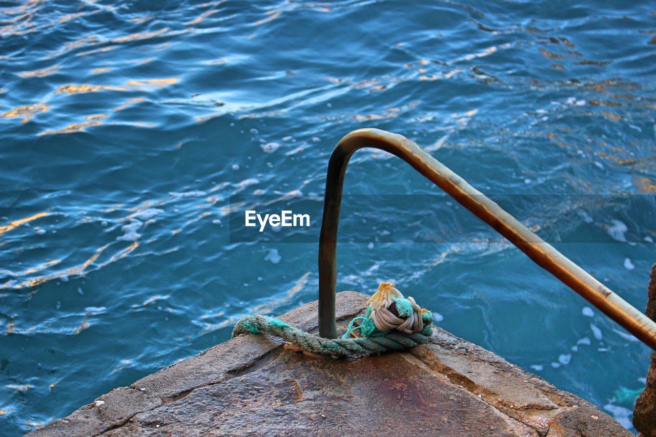 High angle view of rope tied to ocean side