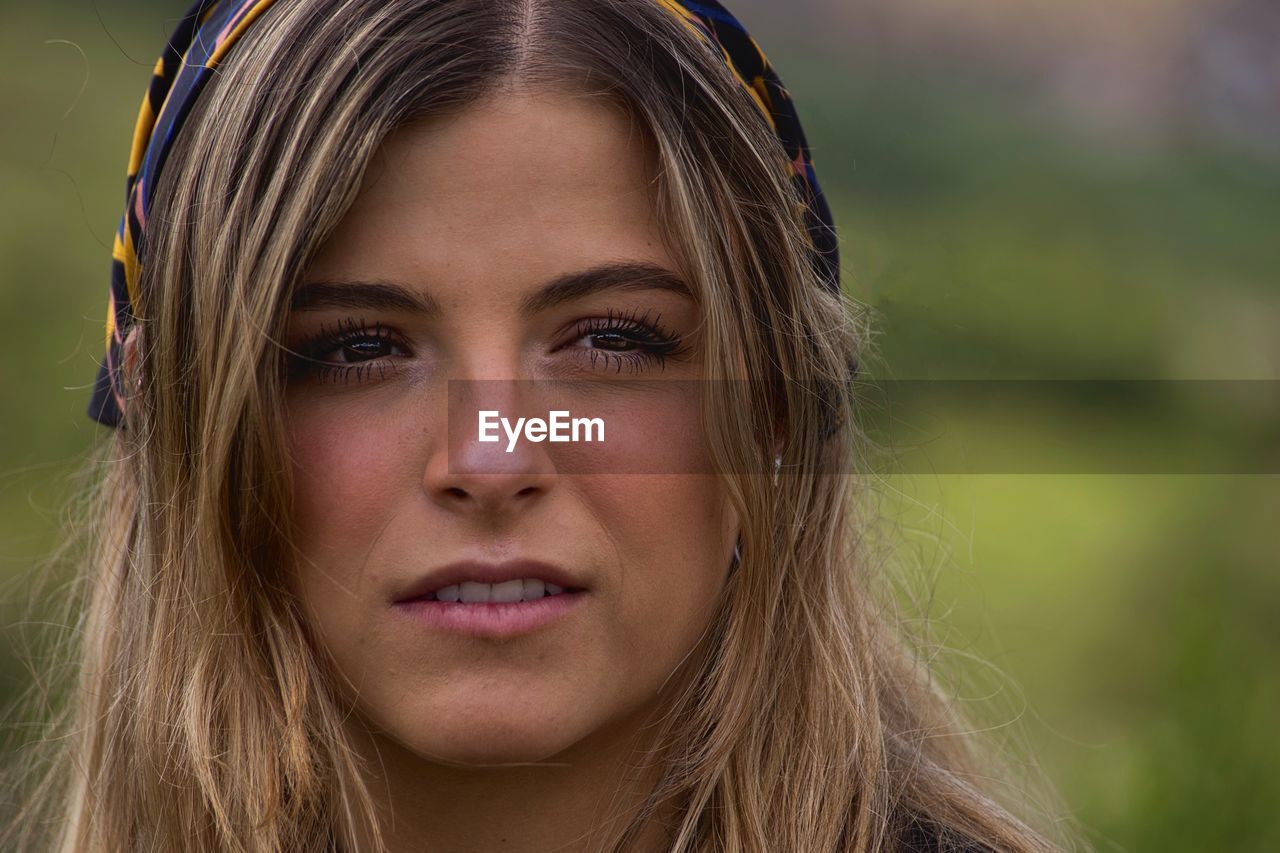 Close-up of beautiful young woman looking away outdoors