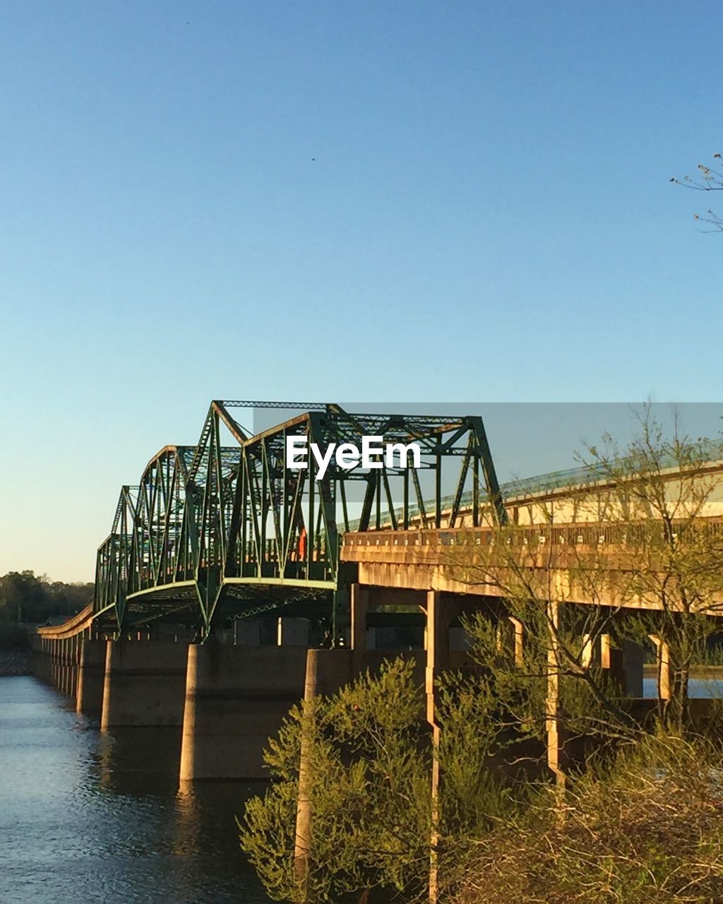 Bridge over river against clear blue sky