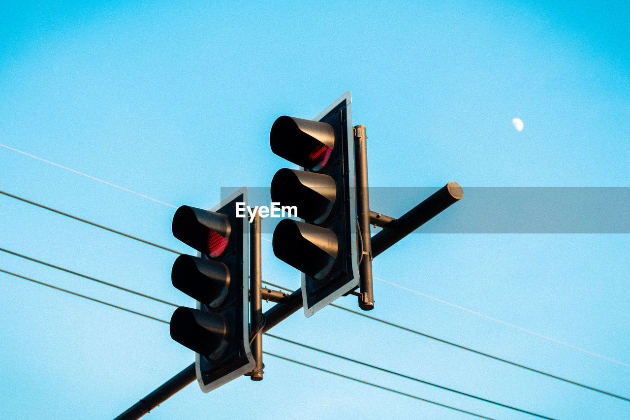 Low angle view of traffic signal against clear blue sky