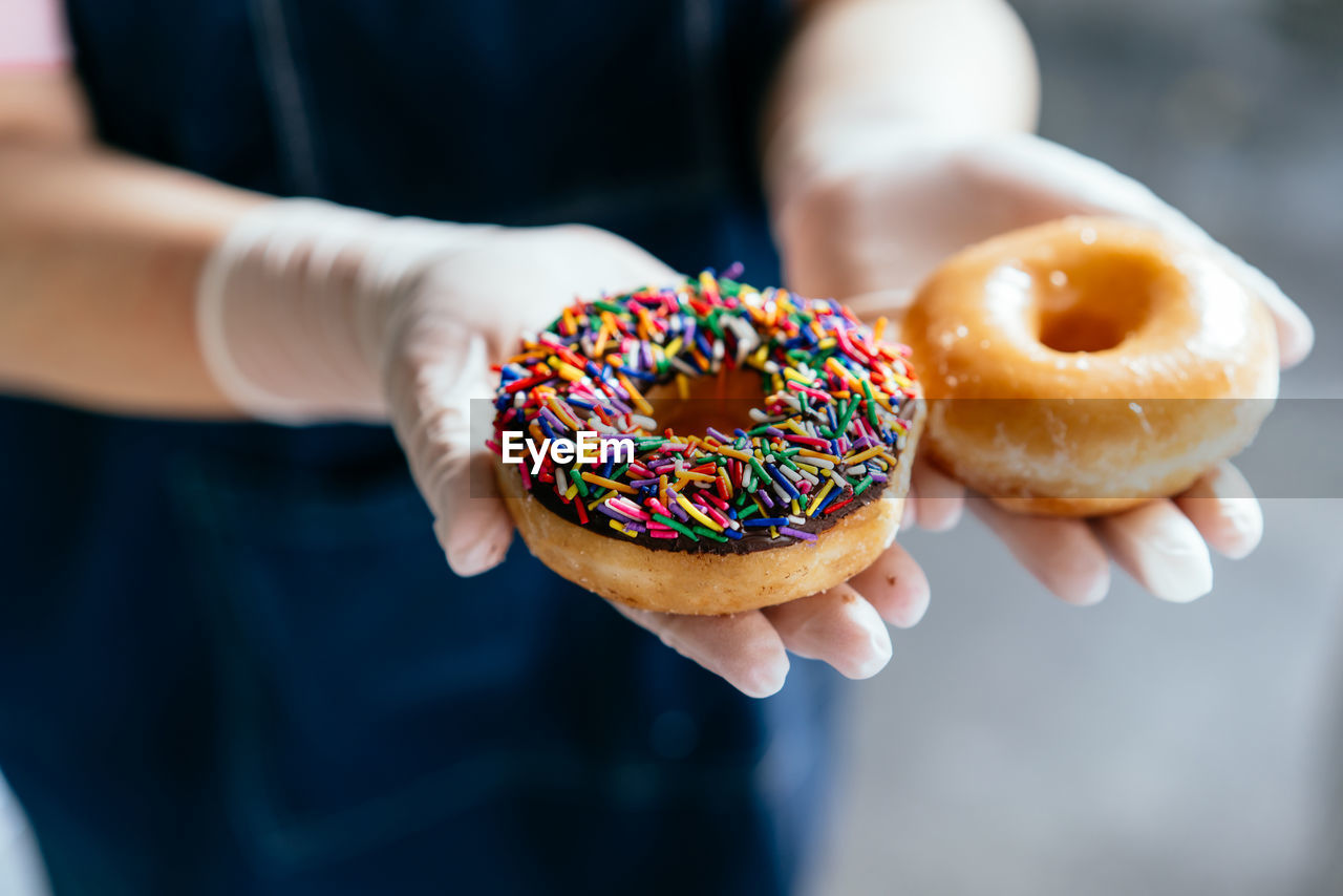 Midsection of woman holding donut