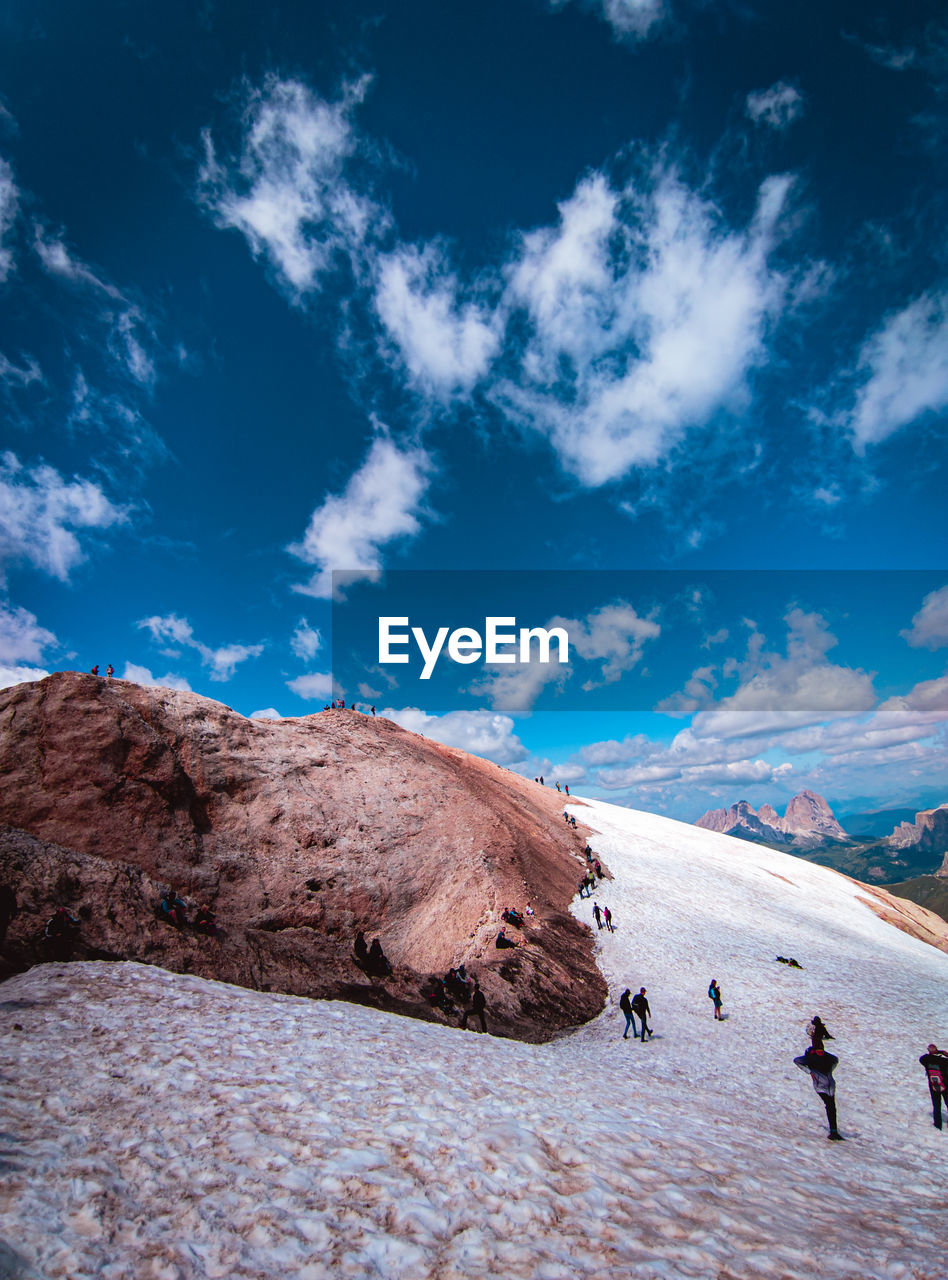 PEOPLE ON ROCK AGAINST SKY